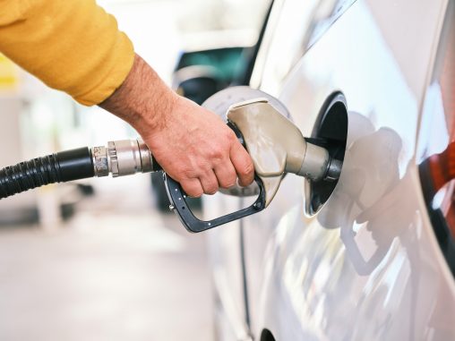 Eine Hand hält ein Zapfventil ins Auto, um es zu betanken